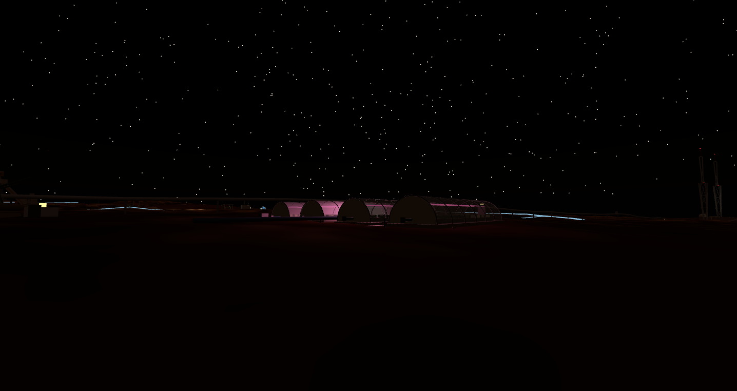 Greenhouse row glowing pink at night